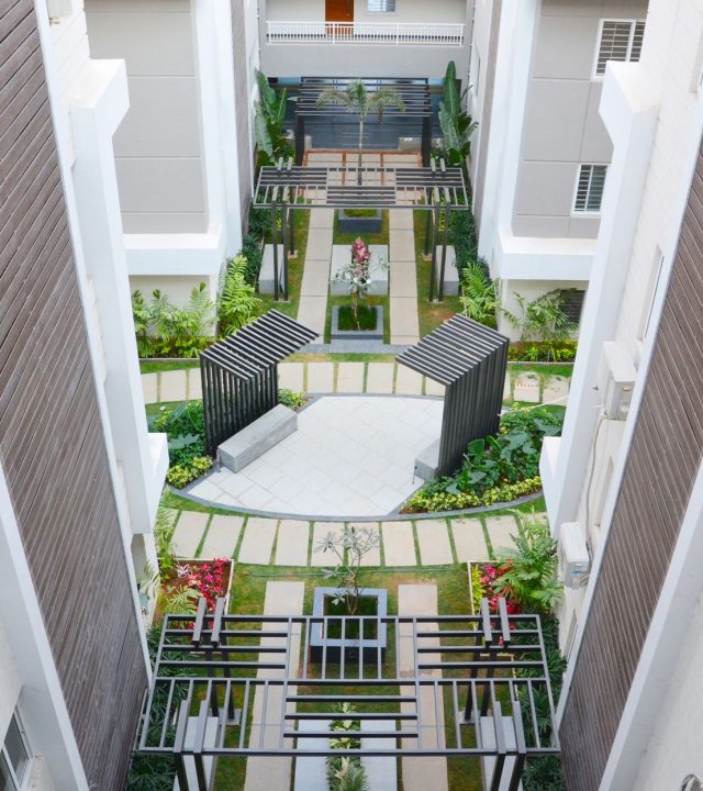 Aerial view of a stylish apartment courtyard with lush gardens in Hyderabad, India.